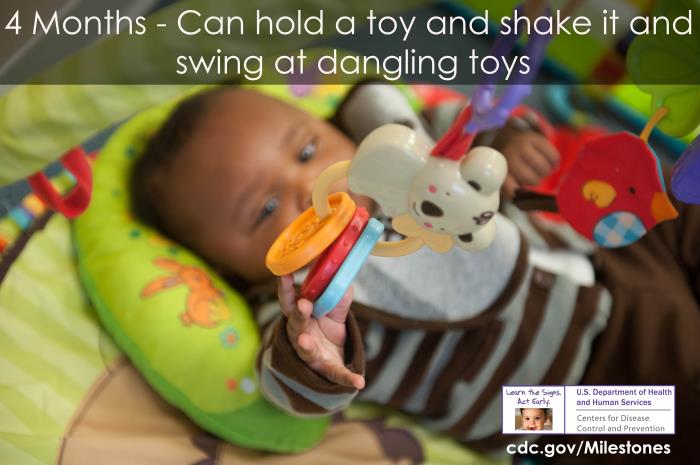 Can hold a toy and shake it and swing at dangling toys