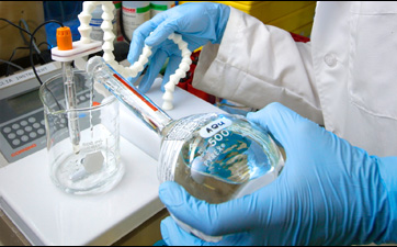 This close-up photograph shows Jason Tully, a CDC laboratorian, using the pH meter in order to prepare a buffer solution in the Personal Care Products Laboratory (PCPL) located in the CDC's Chamblee, Georgia facilities